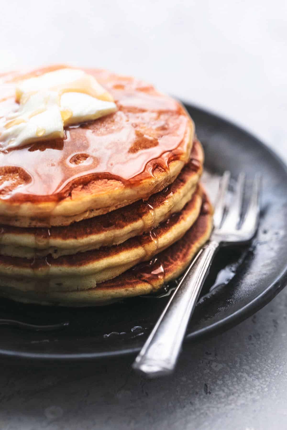 Pfannkuchen mit Butter und Sirup auf einem Teller mit einer Gabel