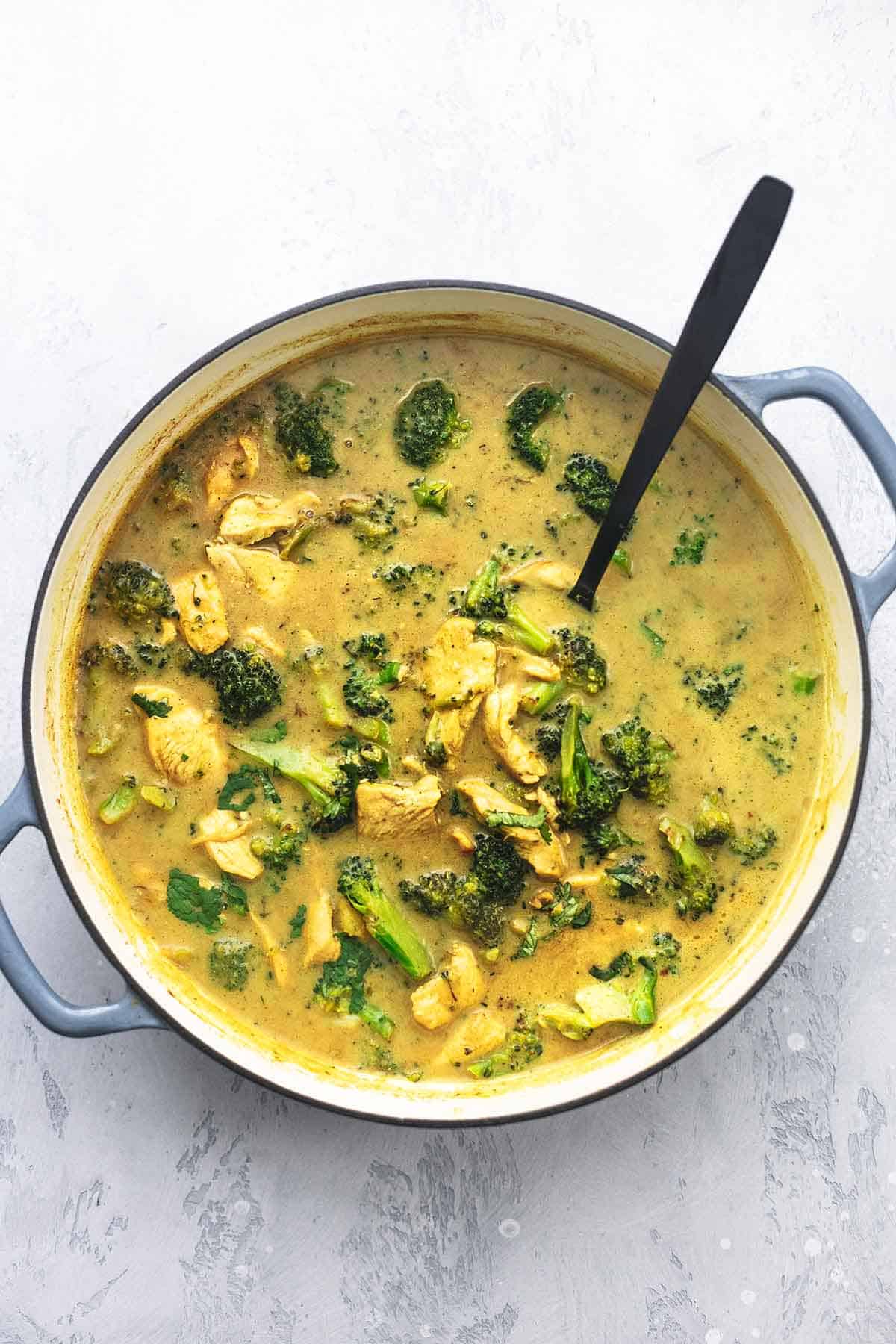 Huhn und Curry mit Brokkoli in einem Topf mit einem Löffel